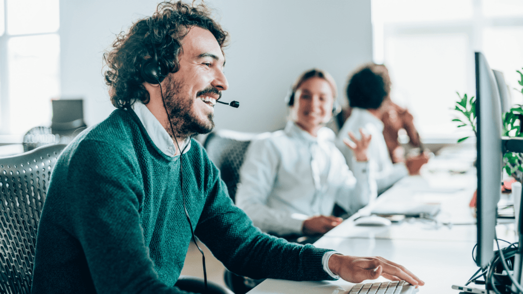 outsourced IT during an economic downturn blog feature image depicting happy call center workers.