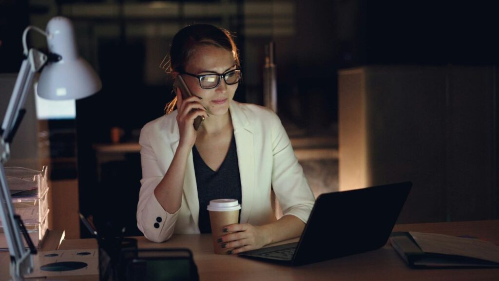 after hours help desk woman working late at night on the phone