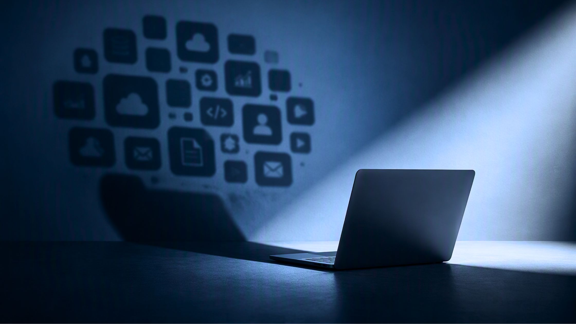 what is shadow IT blog featured image of computer in light with shadow IT icons on wall