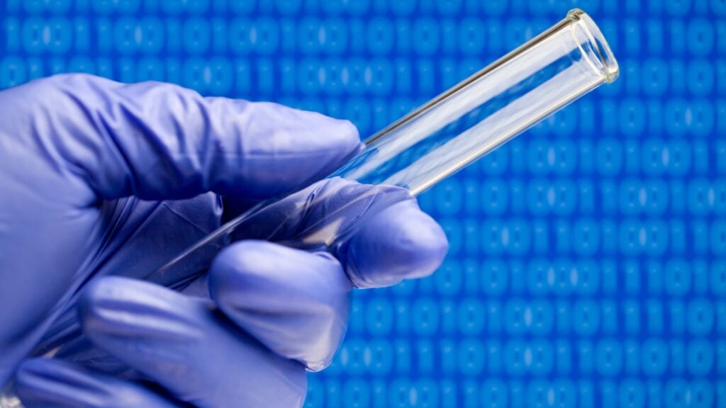 IT Challenges in Biotech blog featured image of lab tech holding test tube with computer code in the background